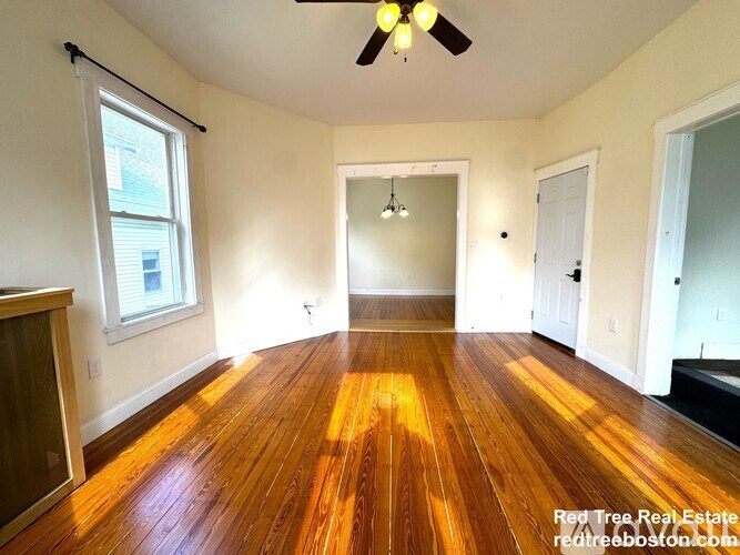 A room with wooden floors and a ceiling fan.