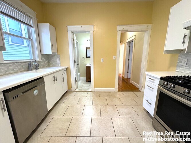 A kitchen with a dishwasher, oven, and cabinets.