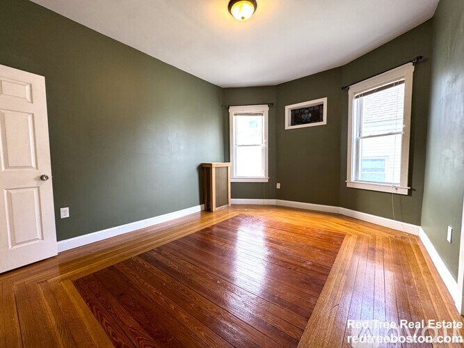 A room with green walls and wooden floors.