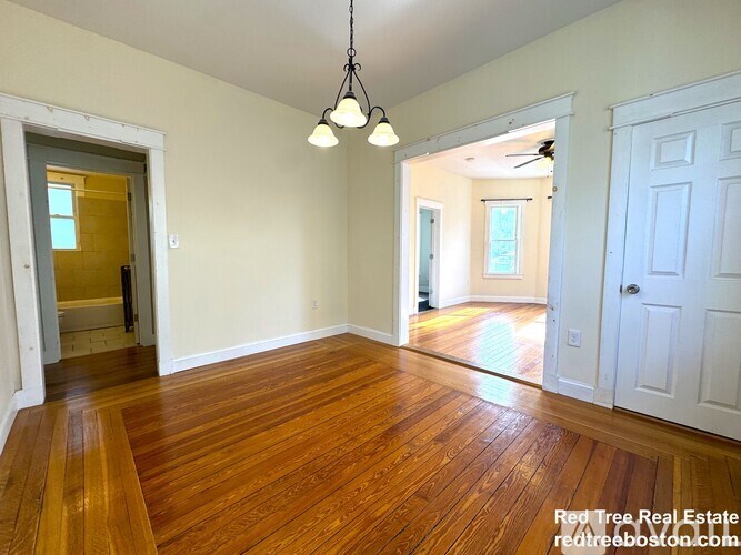 A room with wooden floors and a ceiling fan.