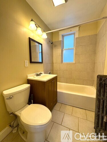 A bathroom with a toilet, sink, and bathtub.