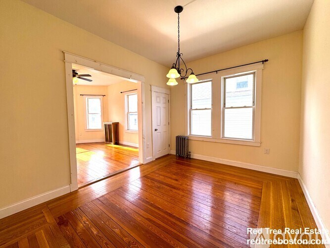 A room with wooden floors and a ceiling fan.