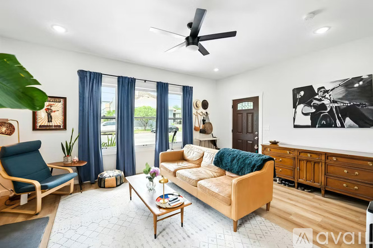 A living room with a blue chair, a beige sofa, and a wooden coffee table.