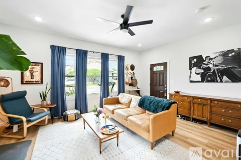A living room with a blue chair, a beige sofa, and a wooden coffee table.