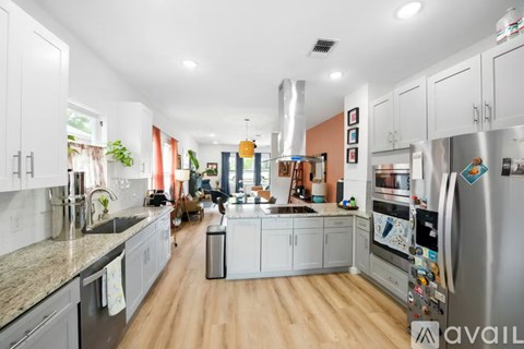 A kitchen with white cabinets and a wooden floor.