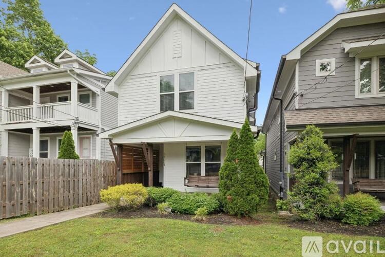 A house with a white facade and a grey roof is shown.