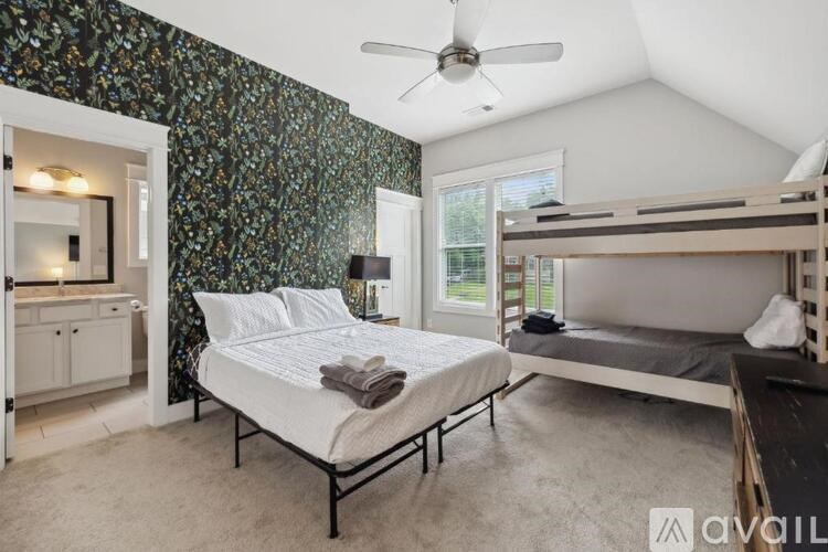 A bedroom with a bed, bunk bed, and a dresser with a mirror.