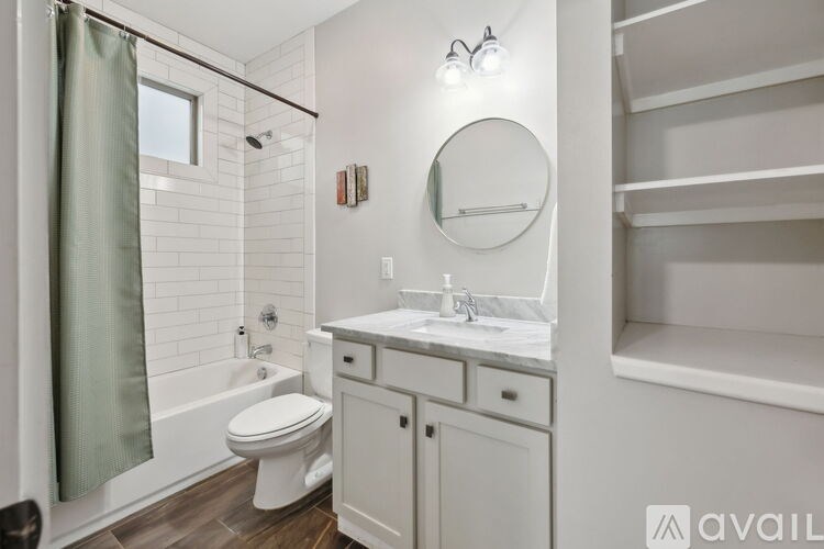 A bathroom with a toilet, sink, and a mirror.