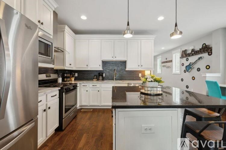 A kitchen with white cabinets and a stainless steel refrigerator.