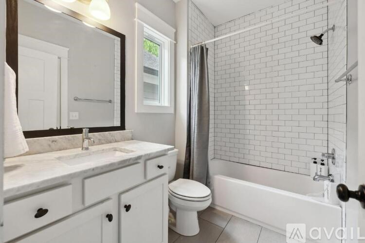 A white bathroom with a toilet, sink, and bathtub.