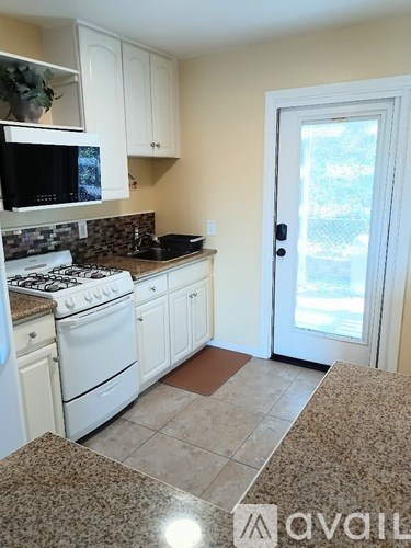 A kitchen with white appliances and cabinets.