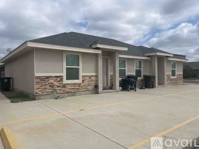 A two-story building with a parking lot in front.