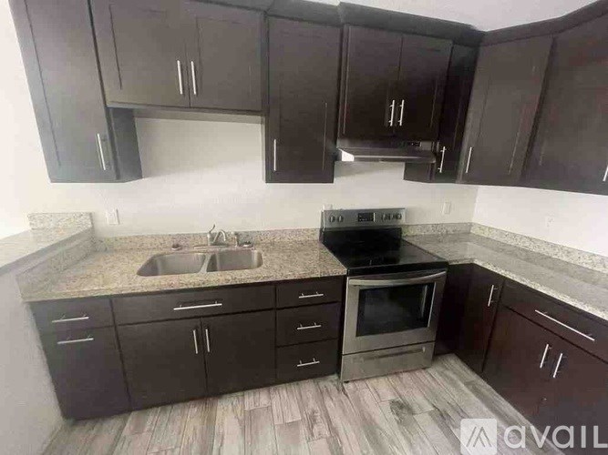 A kitchen with black cabinets and a sink.