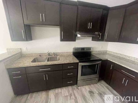 A kitchen with black cabinets and a sink.