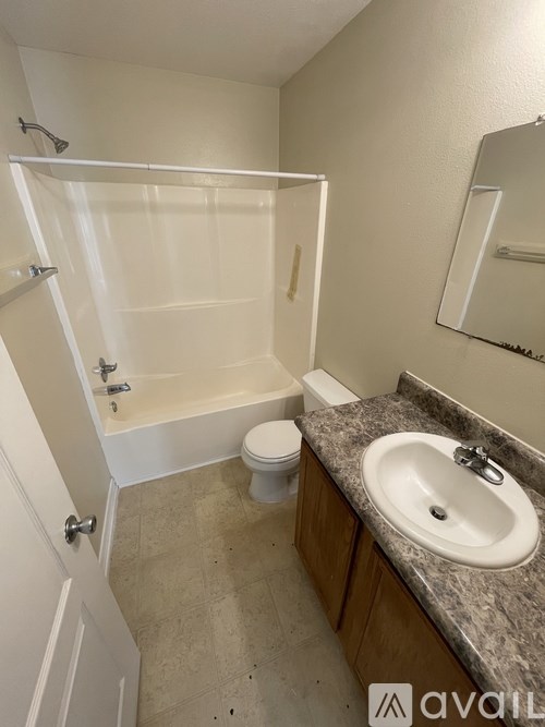 A bathroom with a sink, toilet, and bathtub.