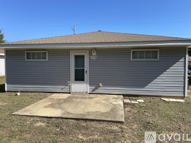 A grey house with a brown door and windows.