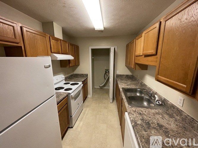 A kitchen with wooden cabinets and a white refrigerator.