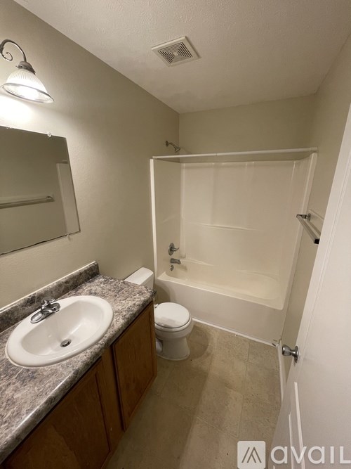 A bathroom with a sink, toilet, and bathtub.