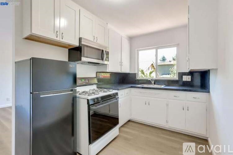 A kitchen with a stainless steel refrigerator, microwave, and stove.
