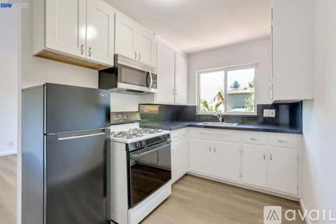 A kitchen with a stainless steel refrigerator, microwave, and stove.