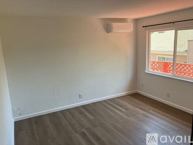 A room with a window and wooden flooring is available.