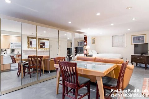 A modern living room with a glass table and chairs.