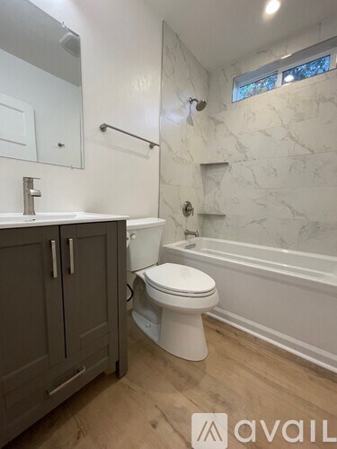 A bathroom with a toilet, sink, and bathtub.