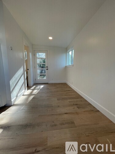 A long hallway with wooden floors and white walls.