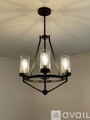 A chandelier with three lights hanging from the ceiling.