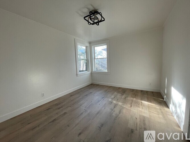 A room with wooden flooring and a ceiling fan.