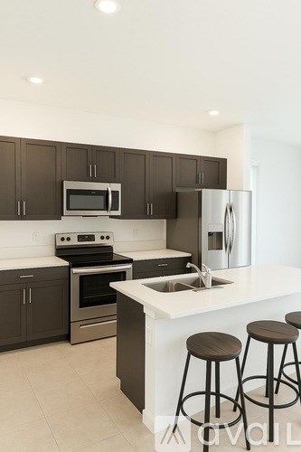 A kitchen with brown cabinets and white countertops.