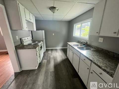 A kitchen with white cabinets and a granite countertop.