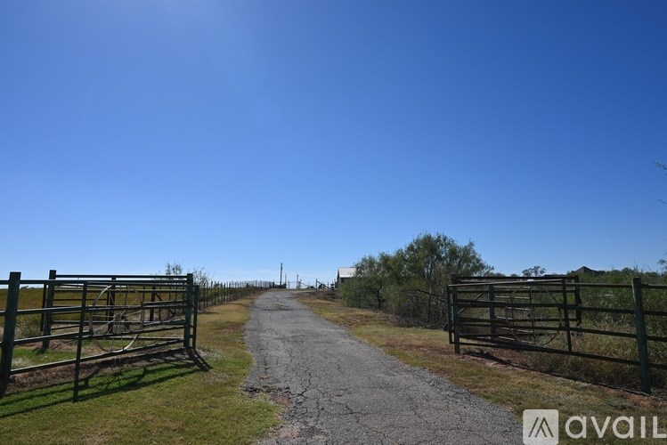 A gravel path leads through a gate into a field.