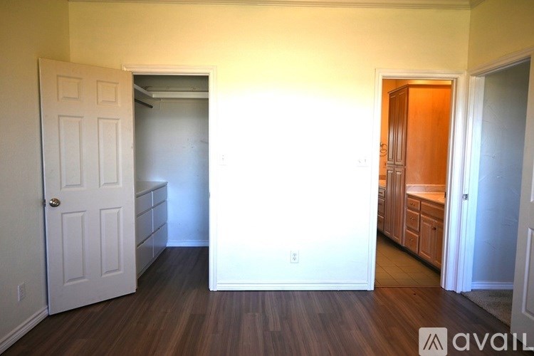 A room with a white door and a wooden floor.