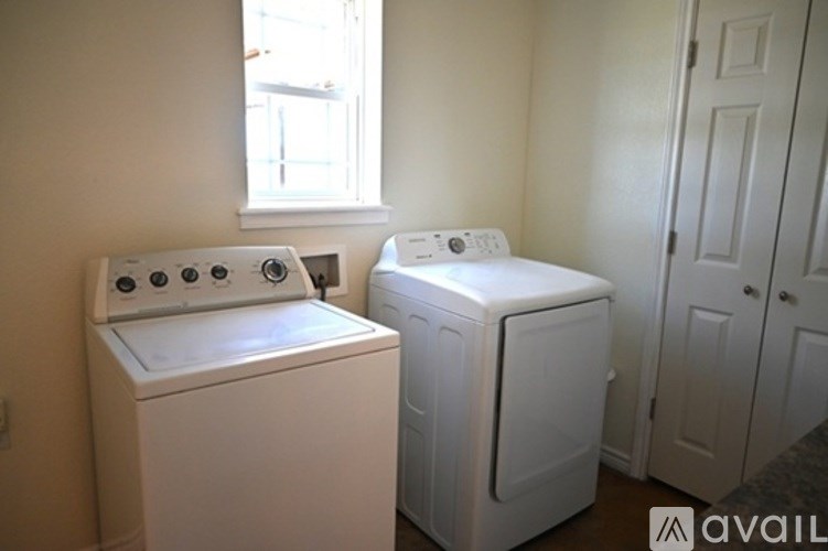 A white washer and dryer in a small room.