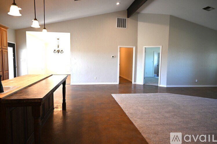 A room with a wooden table and bench, and a rug on the floor.