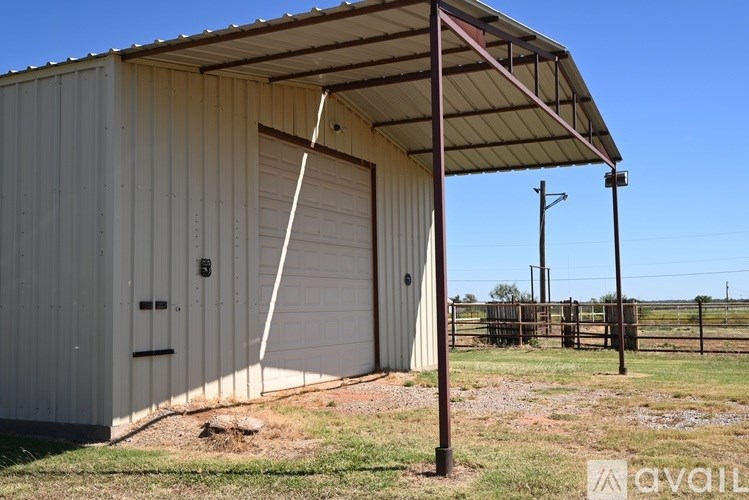 A metal building with a white garage door and a brown roof.