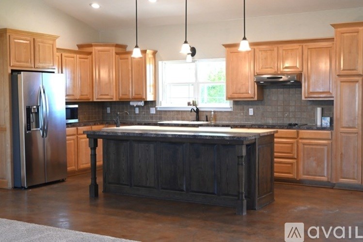 A kitchen with wooden cabinets and a large island.