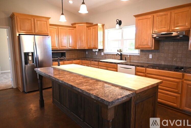 A kitchen with wooden cabinets and a granite countertop.