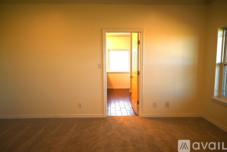 A room with a carpeted floor and a doorway leading to another room.
