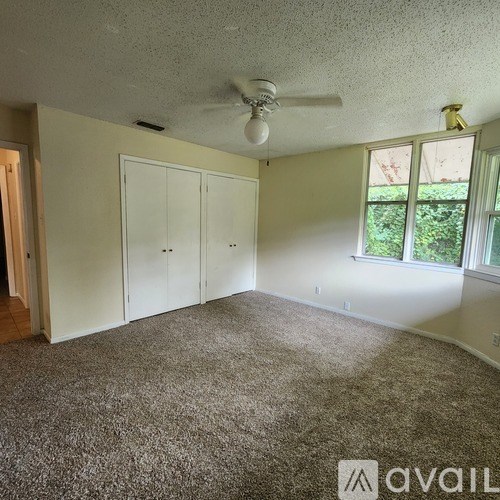 A room with a ceiling fan and two doors.