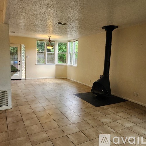 A room with a black stand in the middle of a tiled floor.