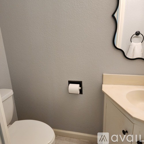A white toilet sits next to a sink in a bathroom.