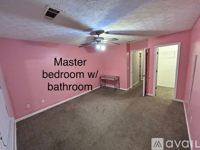 A room with pink walls and a master bedroom with a bathroom.