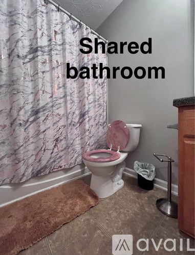 A bathroom with a pink toilet and a shower curtain.