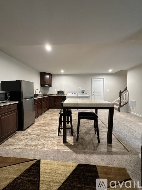 A kitchen with a table and chairs in the middle of the room.