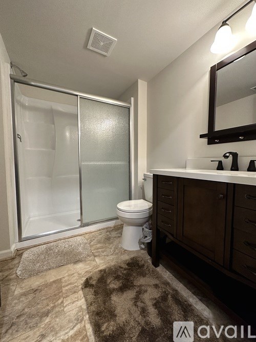 A bathroom with a toilet, sink, and shower.