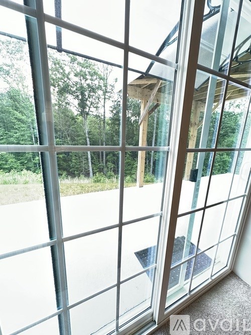 A glass door with a view of a green outdoor area.