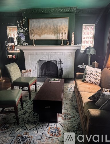 A living room with a fireplace and a painting above it.