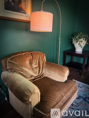 A brown recliner chair is in front of a green wall.